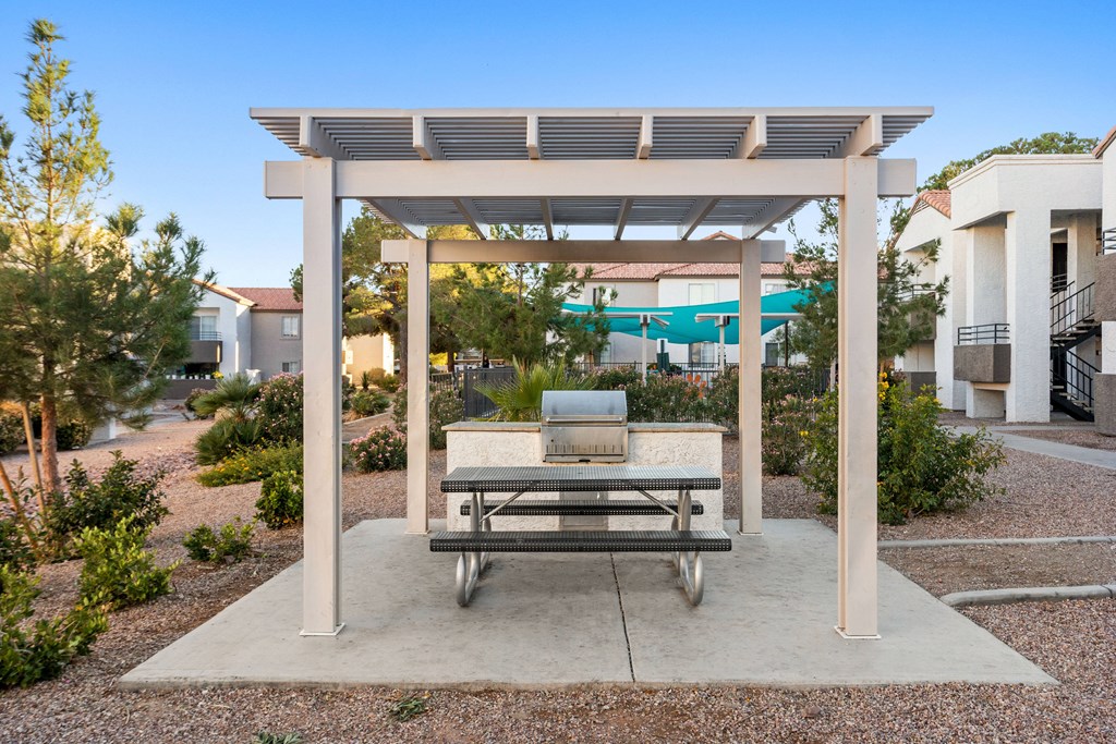 a pergola with a bench and a pool in the background